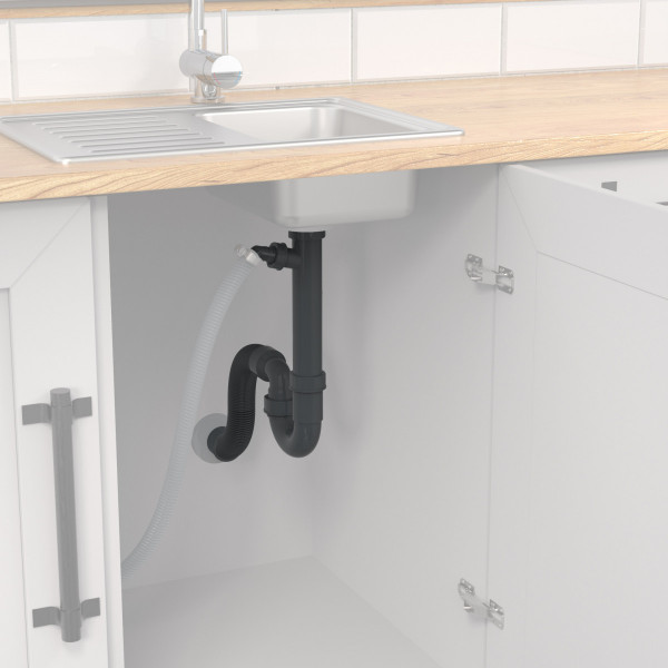 Schwarzer Siphon und Ablaufschlauch unter einer Edelstahlspüle in weißem Küchenschrank.