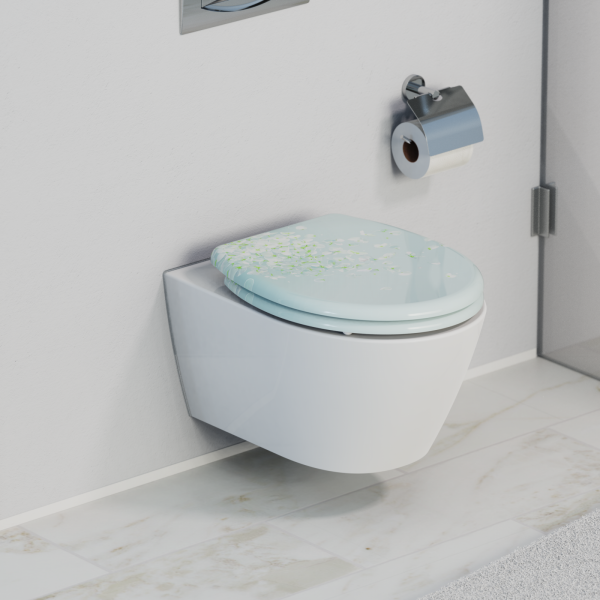Wandhängendes WC mit hellblauem Toilettensitz und floralem Muster, daneben Papierhalter.