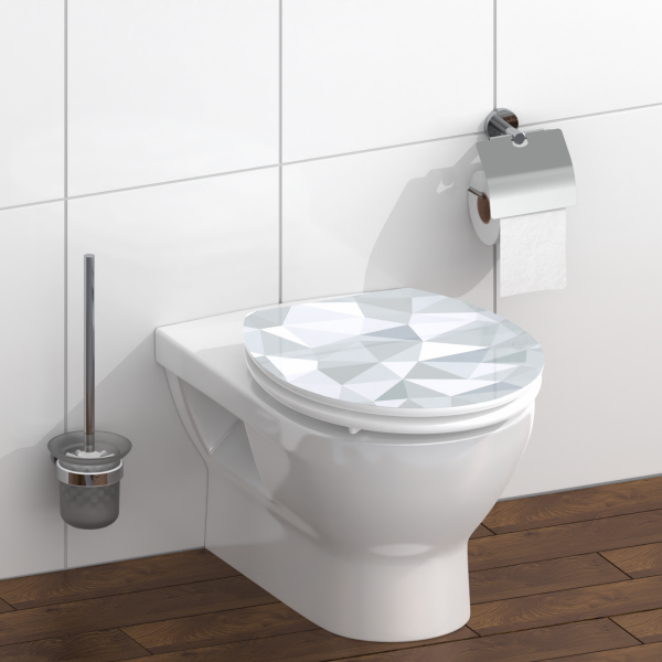 Wandhängendes WC mit geschlossenem WC-Sitz in grauem Facettenmuster und Toilettenbürste.