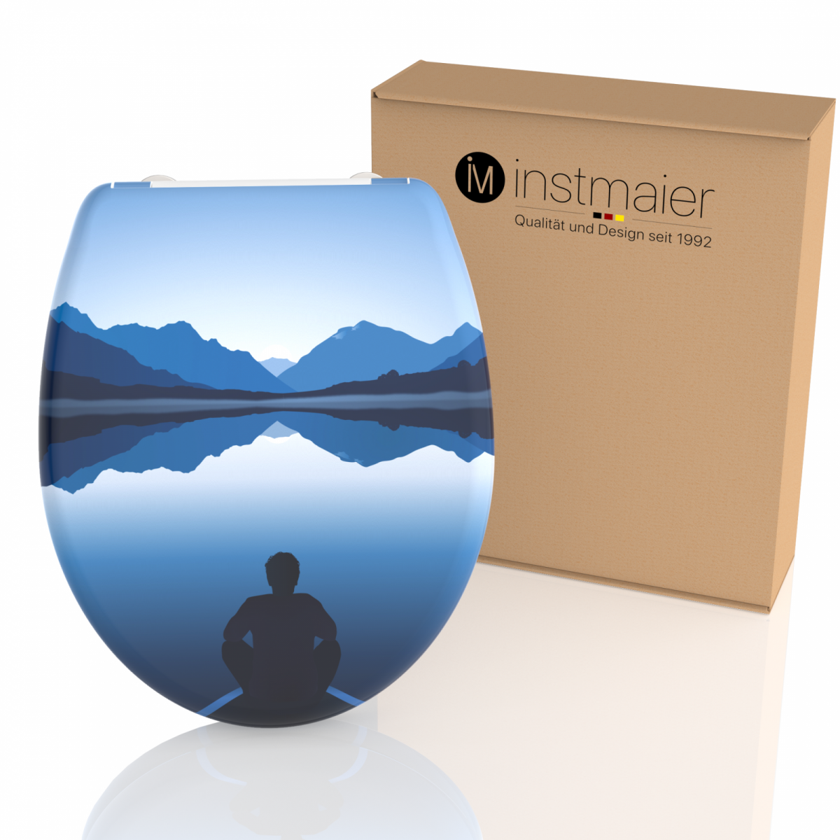 Toilettensitz mit Motiv einer sitzenden Person vor blauem Bergsee und Spiegelung.