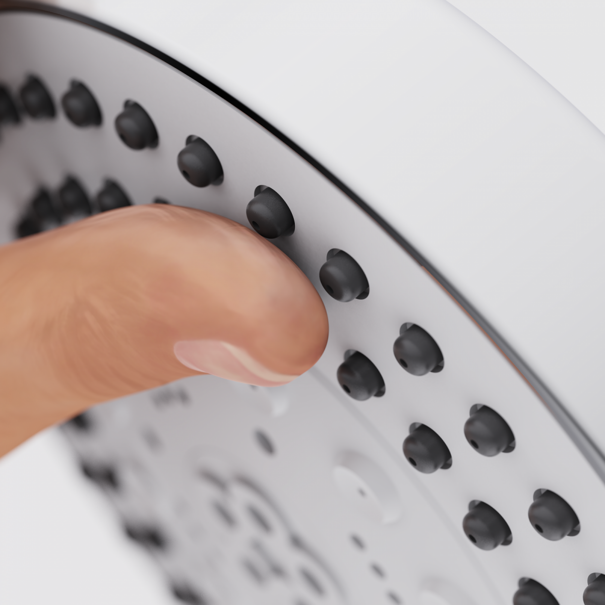 Finger berührt die schwarzen Düsen einer silbernen Duschbrause.