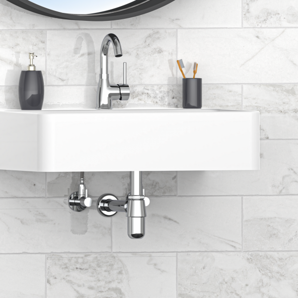 Weißes Wandwaschbecken mit verchromter Armatur und sichtbarem Siphon vor Fliesenwand.
