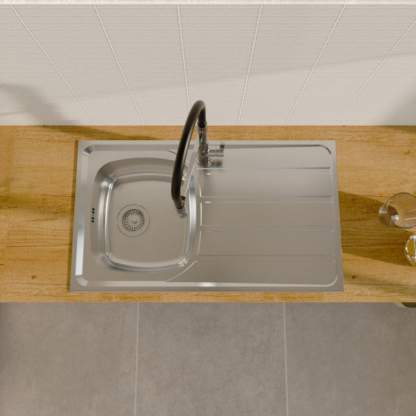 Edelstahlspüle mit Abtropffläche und hohem Wasserhahn auf Holzarbeitsplatte.