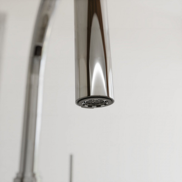 Nahaufnahme eines verchromten Wasserhahnauslaufs mit sichtbarem Strahlregler.