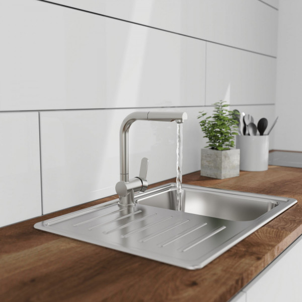 Edelstahl-Küchenarmatur mit laufendem Wasser über Spülbecken und Abtropffläche.