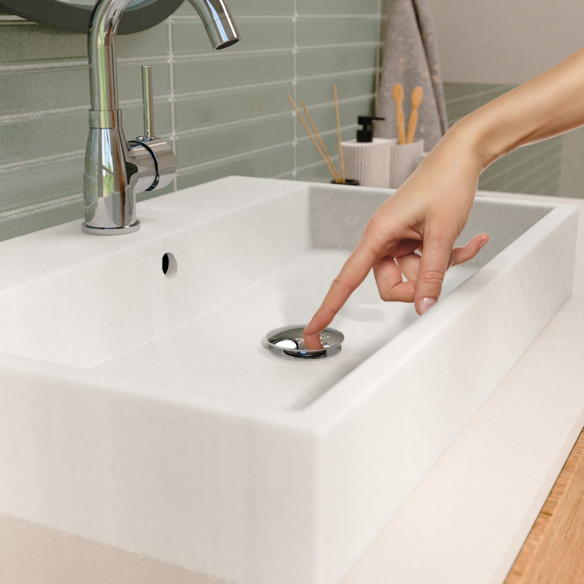Hand drückt auf verchromten Ablaufstopfen in einem weißen Waschbecken unter Wasserhahn.