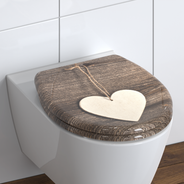 Toilettensitz mit Holzoptik und aufgedrucktem hellen Herzanhänger.