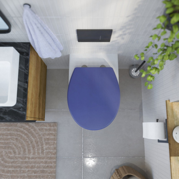 Weiße Toilette mit geschlossenem blauem WC-Sitz in modernem Badezimmer von oben.