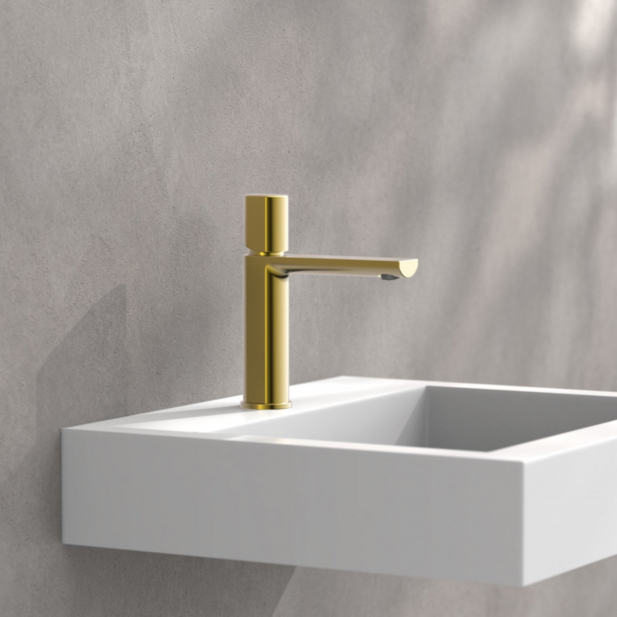 Goldfarbene Einhebelarmatur an weißem, wandmontiertem Waschbecken vor grauer Wand.