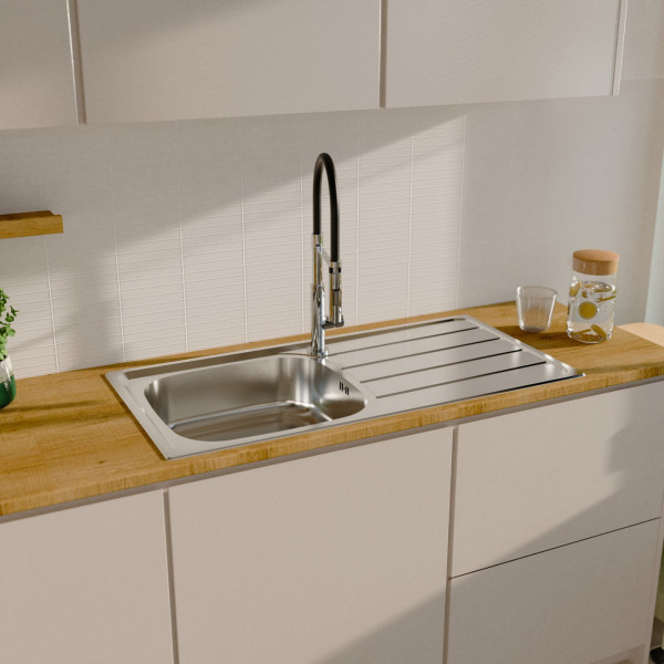 Edelstahlspüle mit Abtropffläche und hohem Wasserhahn in Holzarbeitsplatte eingebaut.