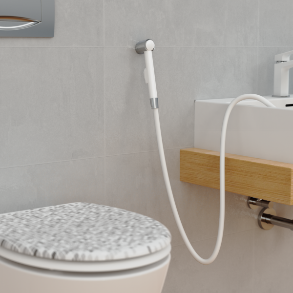 Handbrause mit weiÃem Schlauch an Wand neben Waschbecken und Toilette befestigt