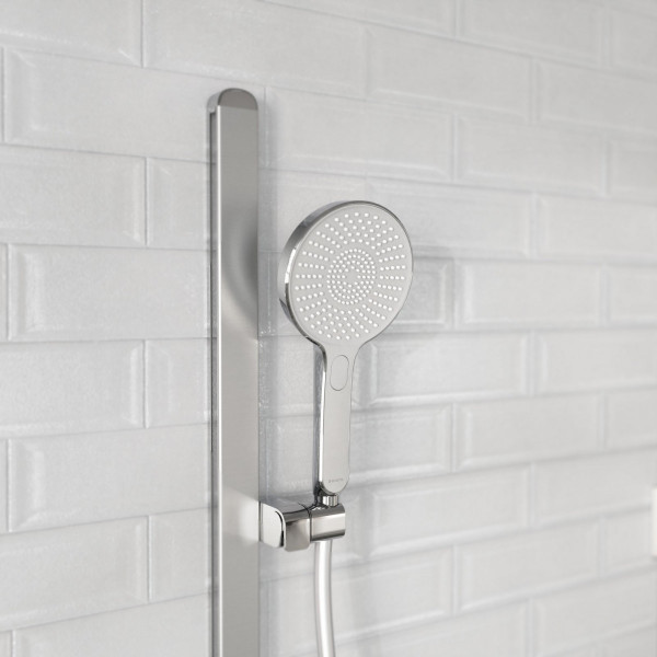 Runde Handbrause aus Chrom an verstellbarer Wandhalterung vor heller Fliesenwand.