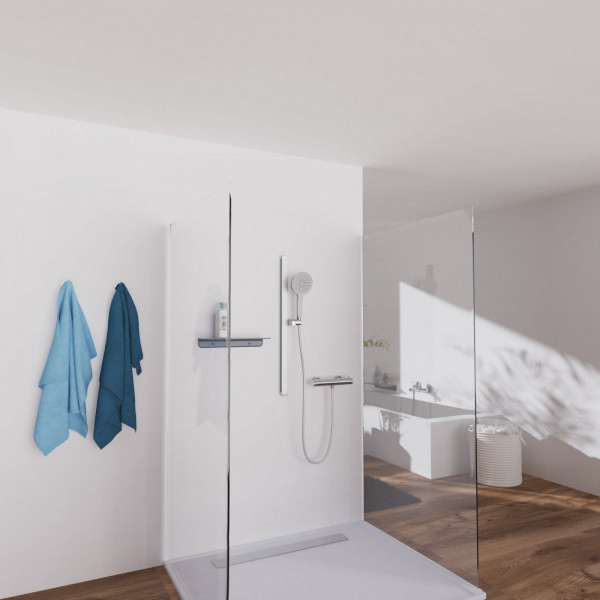 Begehbare Dusche mit Glaswänden, Duschbrause, Ablage und zwei blauen Handtüchern an der Wand.