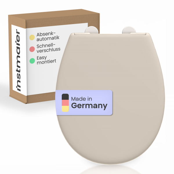Beigefarbener WC-Sitz mit Verpackung im Hintergrund und Aufkleber „Made in Germany“.
