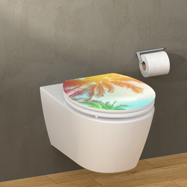 Wandhängende weiße Toilette mit Toilettensitz in Palmenmotiv in warmen Farbtönen.