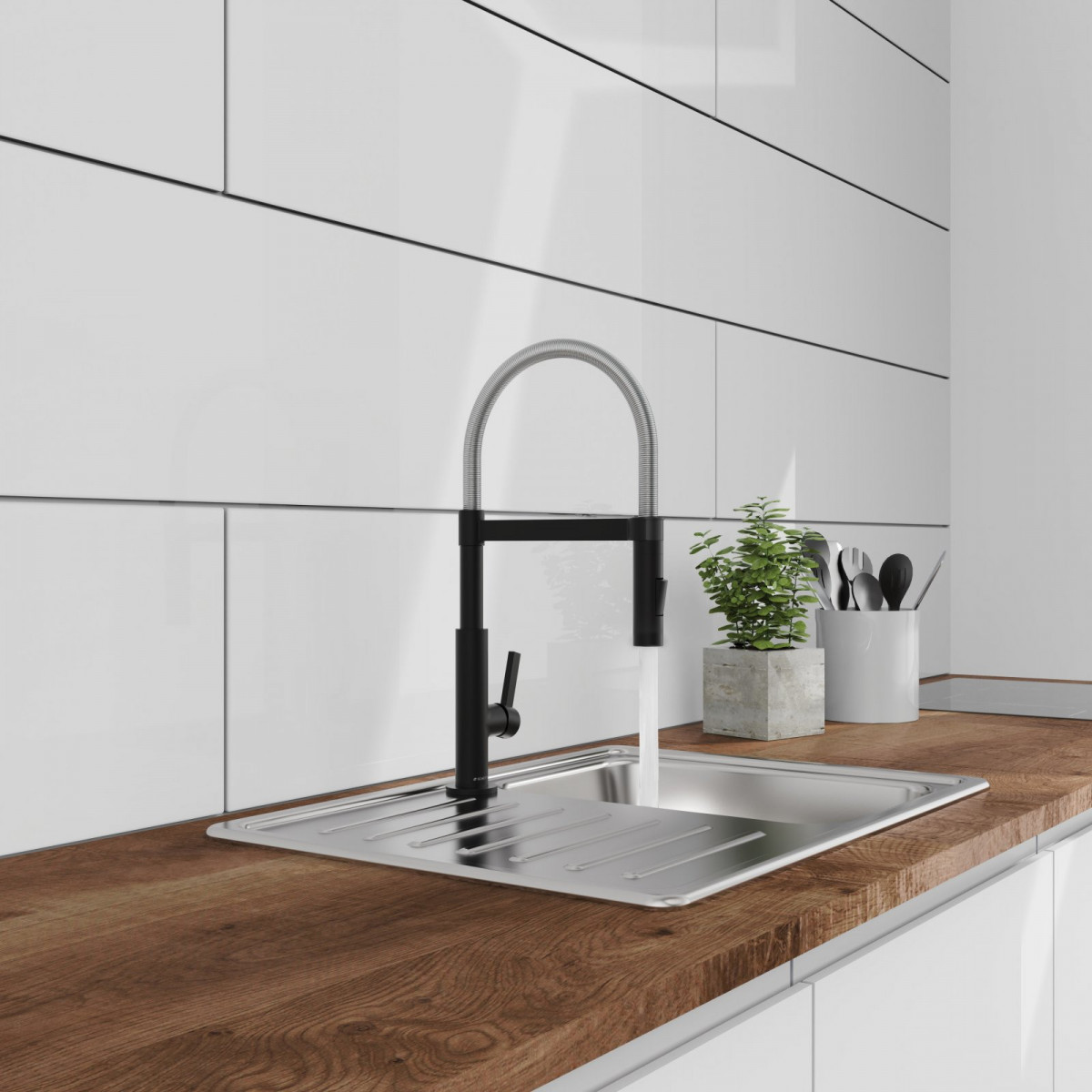 Edelstahlspüle mit hohem Wasserhahn auf Holzarbeitsplatte, daneben Topf mit Küchenutensilien.