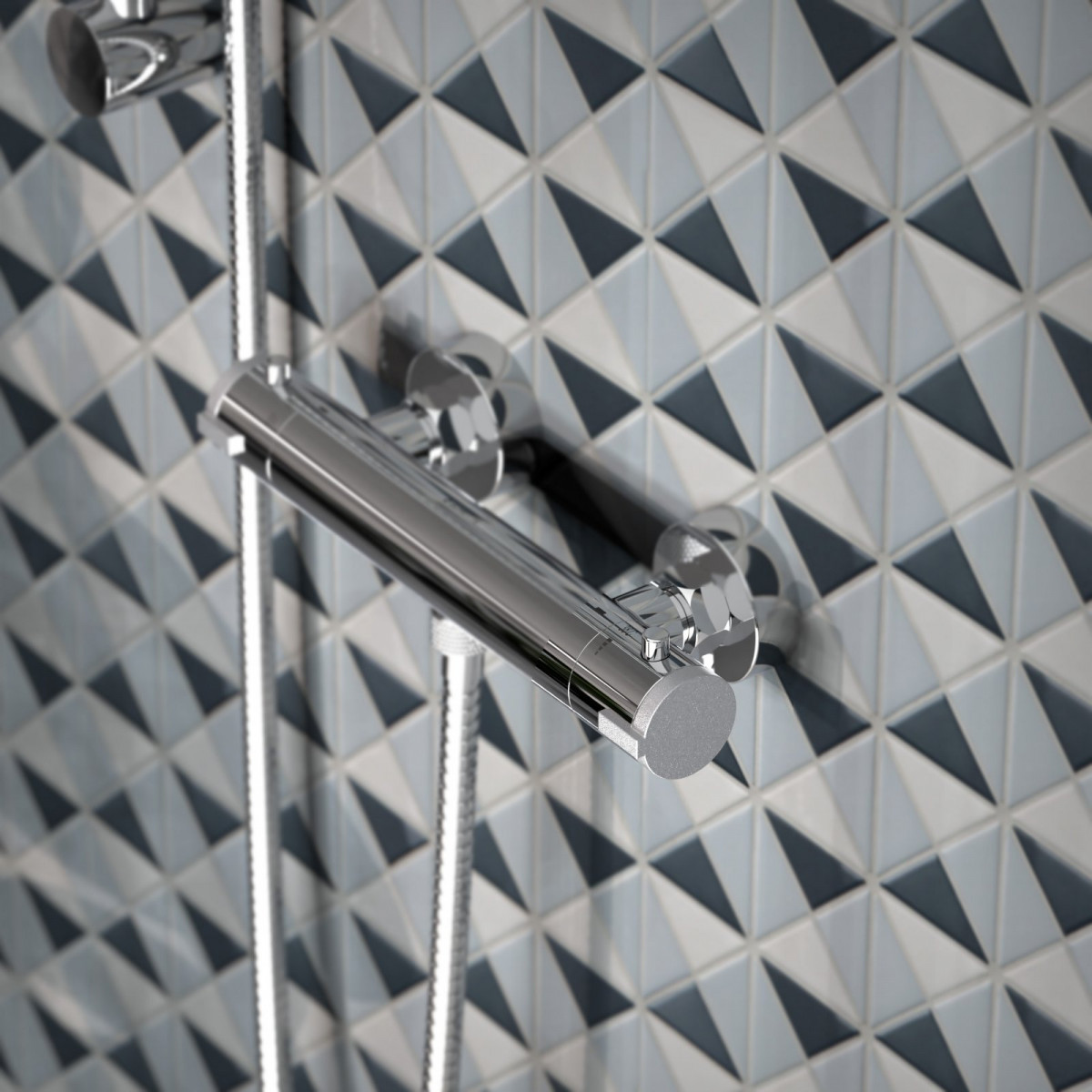 Chromfarbene Duscharmatur mit zwei Drehgriffen vor gefliester Wand in Blau‑Grau‑Tönen.