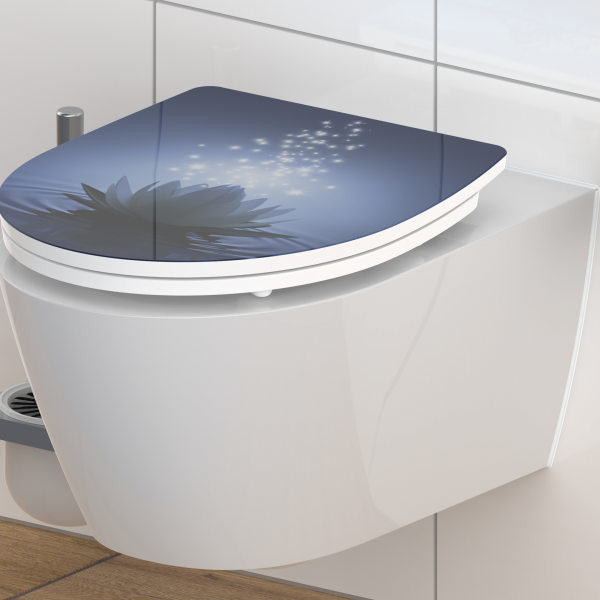 Wandhängendes WC mit WC-Sitz, blauem Deckel und Motiv aus Blüte und Lichtpunkten.