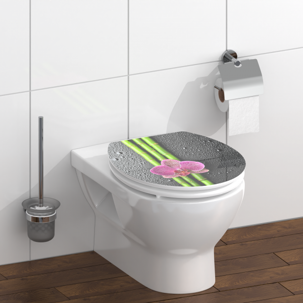 Geschlossene WC-Brille mit Bambus- und Orchideenmotiv in modernem Badezimmer aus Holz.
