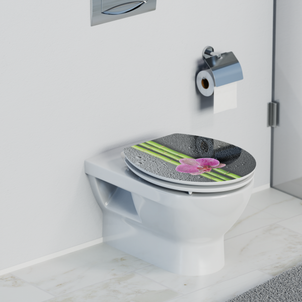 Wandhängende Toilette mit geschlossenem WC-Sitz, Motiv aus Bambus und pinker Blüte.