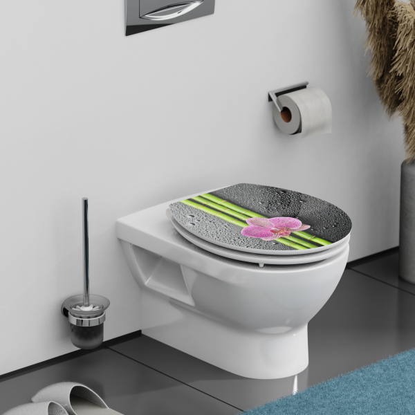 Weiße Wandtoilette mit Toilettendeckel in Bambus- und Blütendesign in Badezimmerumgebung